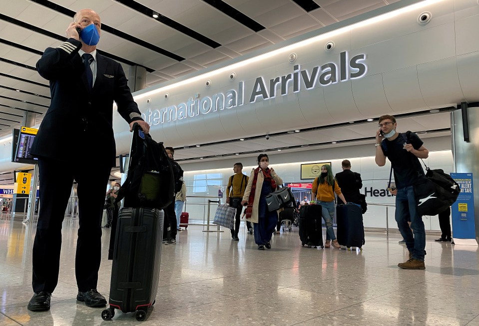 People wearing masks arrive into Heathrow Airport