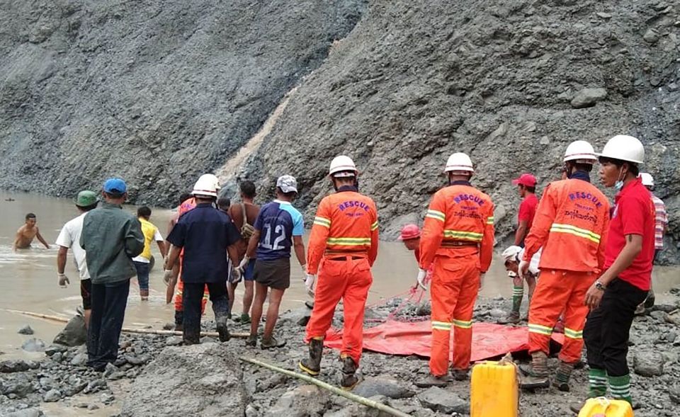 Workers wade through deep waters following the landslide