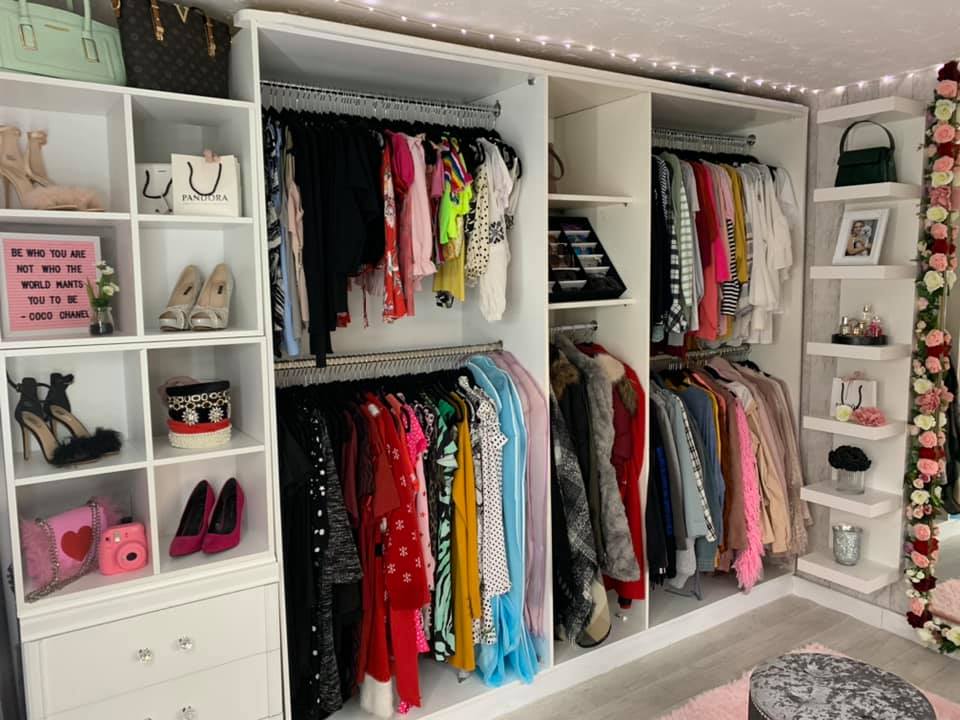 The pair have an open wardrobe lining the room and shoes, handbags and shopping bags on display