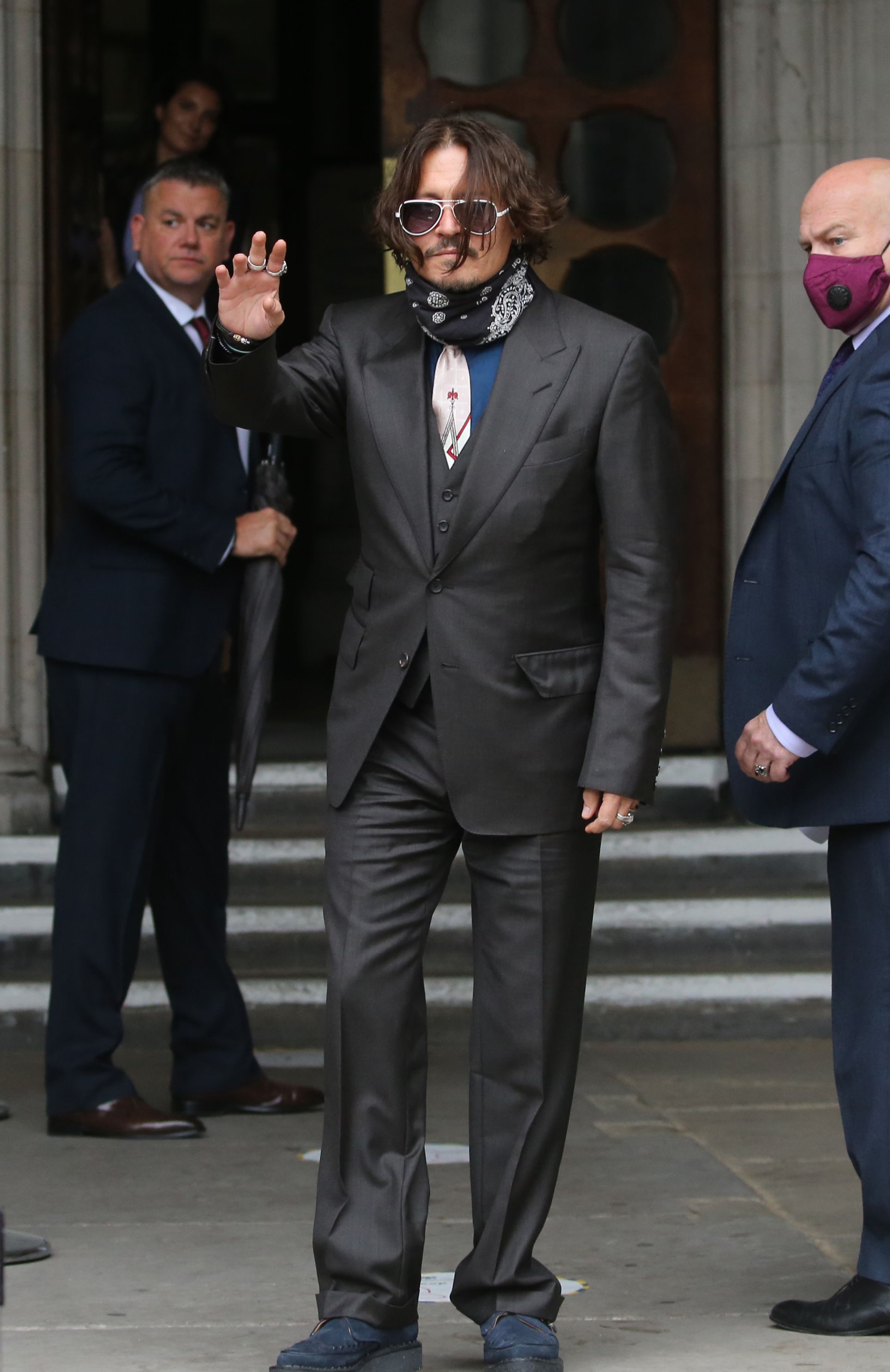 Depp wore a dark grey suit and sunglasses despite the grey weather