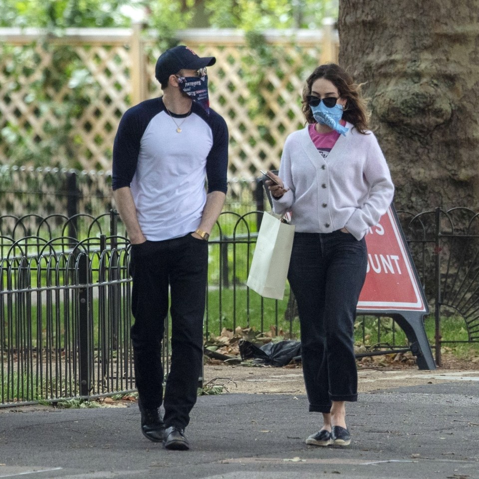 The pair each wore shades and masks as they strolled along the path