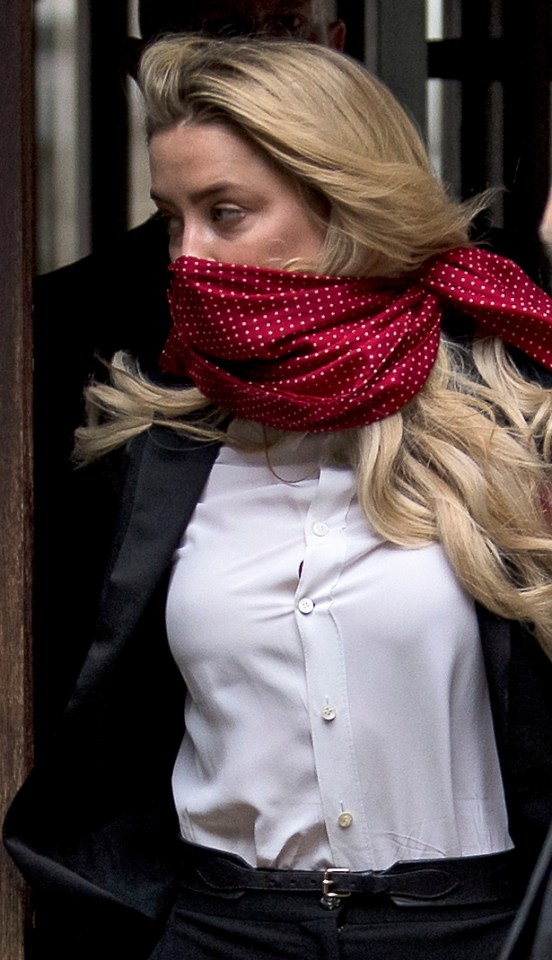 Amber Heard wore a red scarf around her face as she arrived in court today