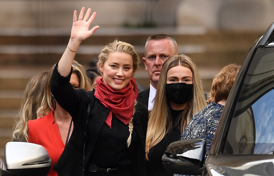 Amber Heard waves as she leaves court in London on Monday