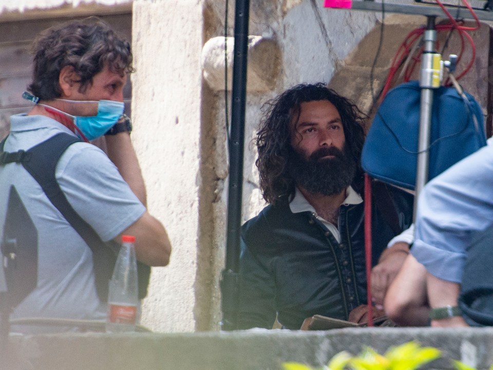 Aidan pictured back on set filming the show in Viterbo, Italy sporting a big black beard and longer hair