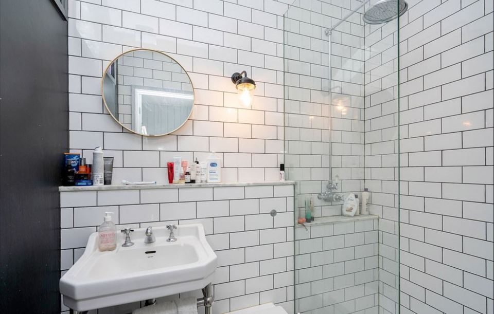 The bathroom has a modern tiled finish