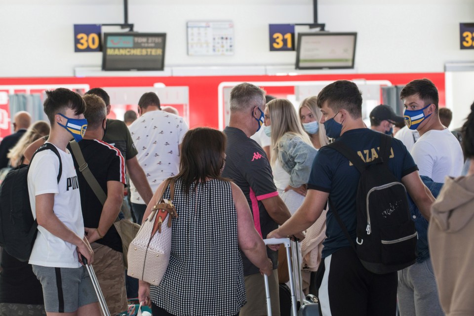 Travelers heading to Manchester queue up at the check-in in San Bartolome airport in Lanzarote