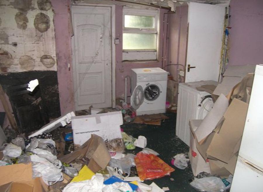 In one room, rubbish almost entirely covers the floors, with cardboard boxes, plastic bags and bottles stacked high 