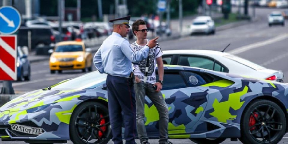 Maksim Yakubets speaks to a cop in front of his personalised Lamborghini