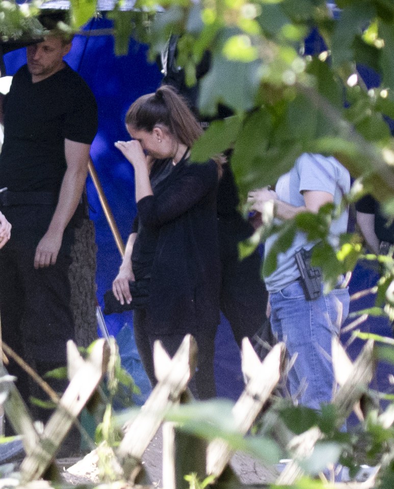 A German police officer wipes her eye at yesterday's dig