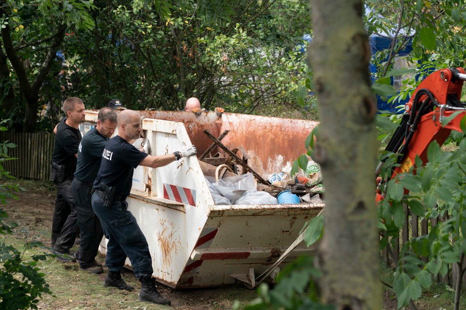 Officers with a skip containing what appears to be rubbish and debris from the site