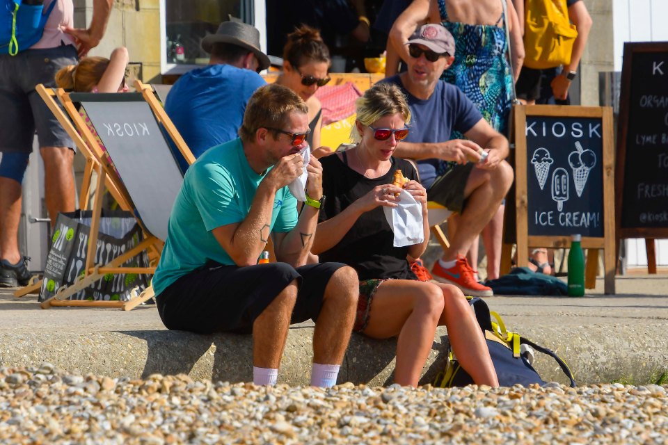 A pair of beachgoers enjoy a seaside breakfast