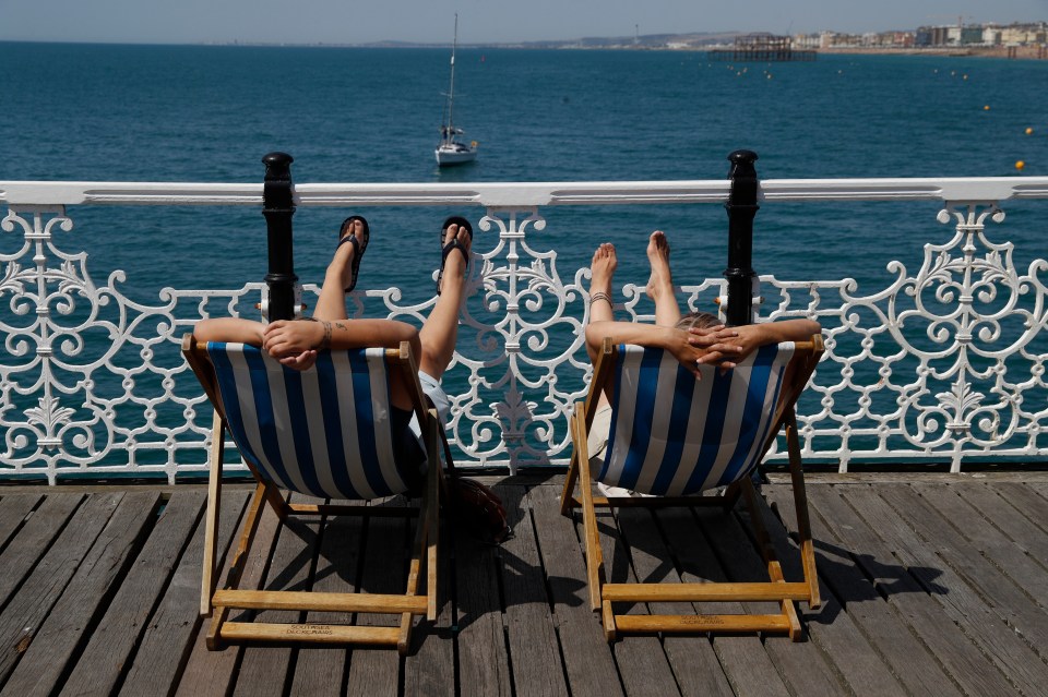 Two sun lovers relax in deckchairs in Brighton