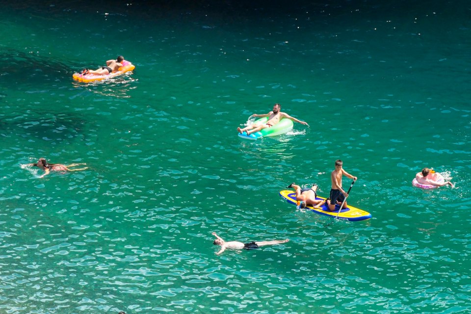 Swimmers in Durdle Door's sparkling seas