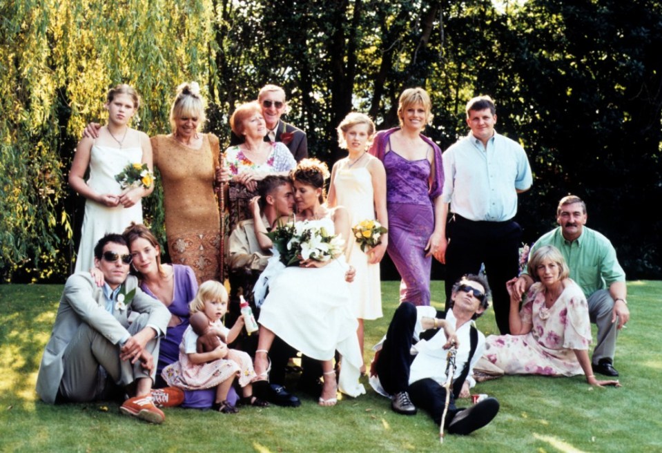 Angela Jennings (centre right), daughter of British rock and Roll guitarist Keith Richards, poses with her new husband Dominic Jennings (centre right) and their wedding guests. Her famous father sits on the ground looking up at the sky