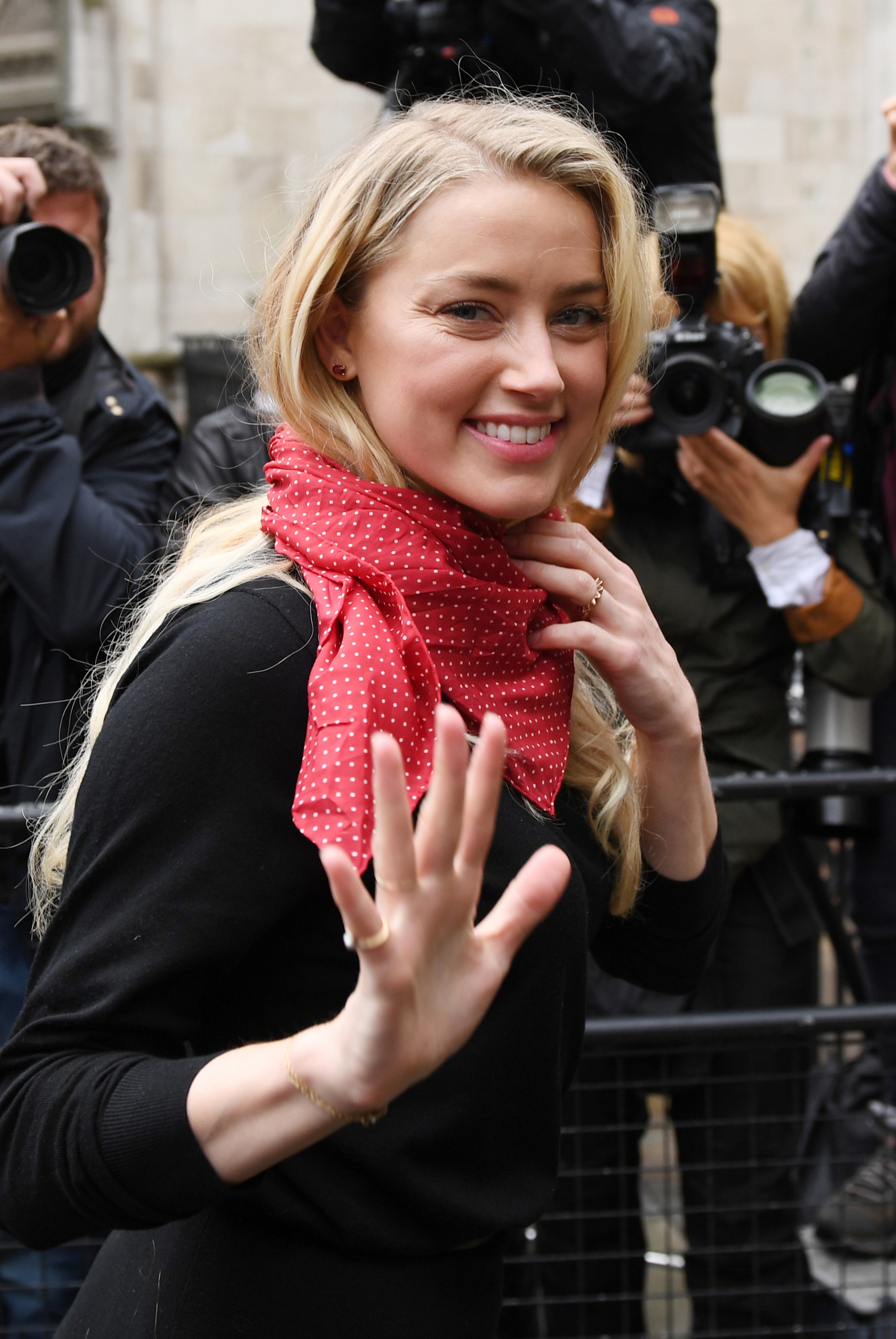 Amber Heard beams as she arrives at the High Court today