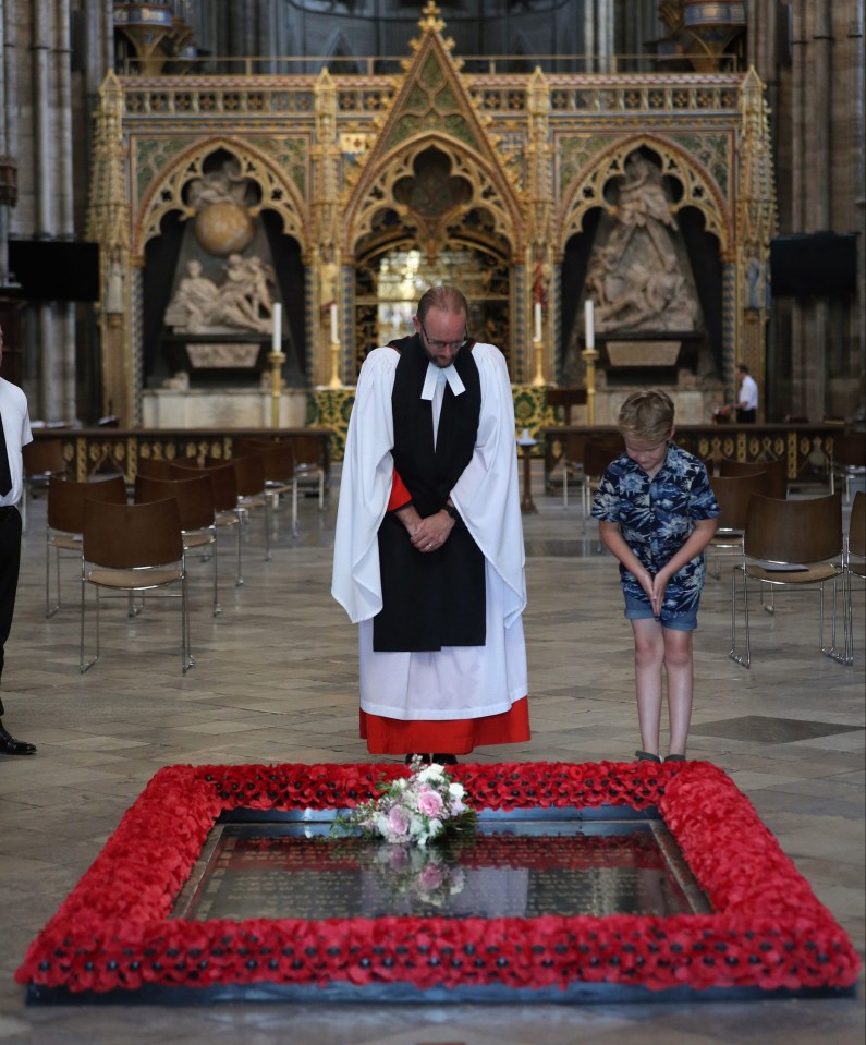 Reverend Anthony Ball places Beatrice's bouquet on the Tomb of the Unknown Warrior in Westminster Abbey