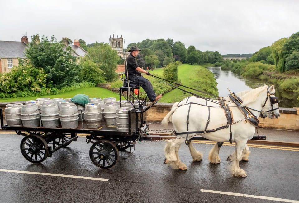 A horse-drawn cart helps Samuel Smith’s brewery deliver casks of beer to local pubs in Tadcaster, North Yorkshire