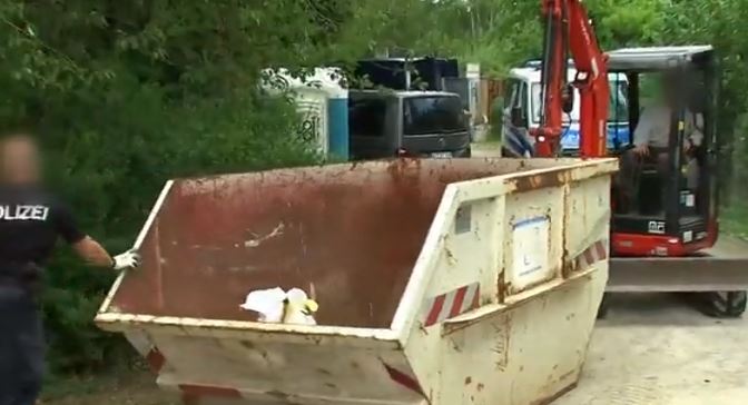 A white bag being taken away in the back of a skip 