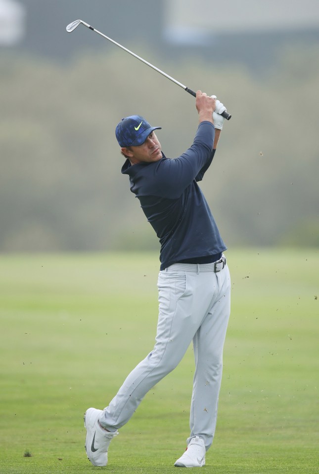 Reigning champion Brooks Koepka plays his second shot at the 18th hole