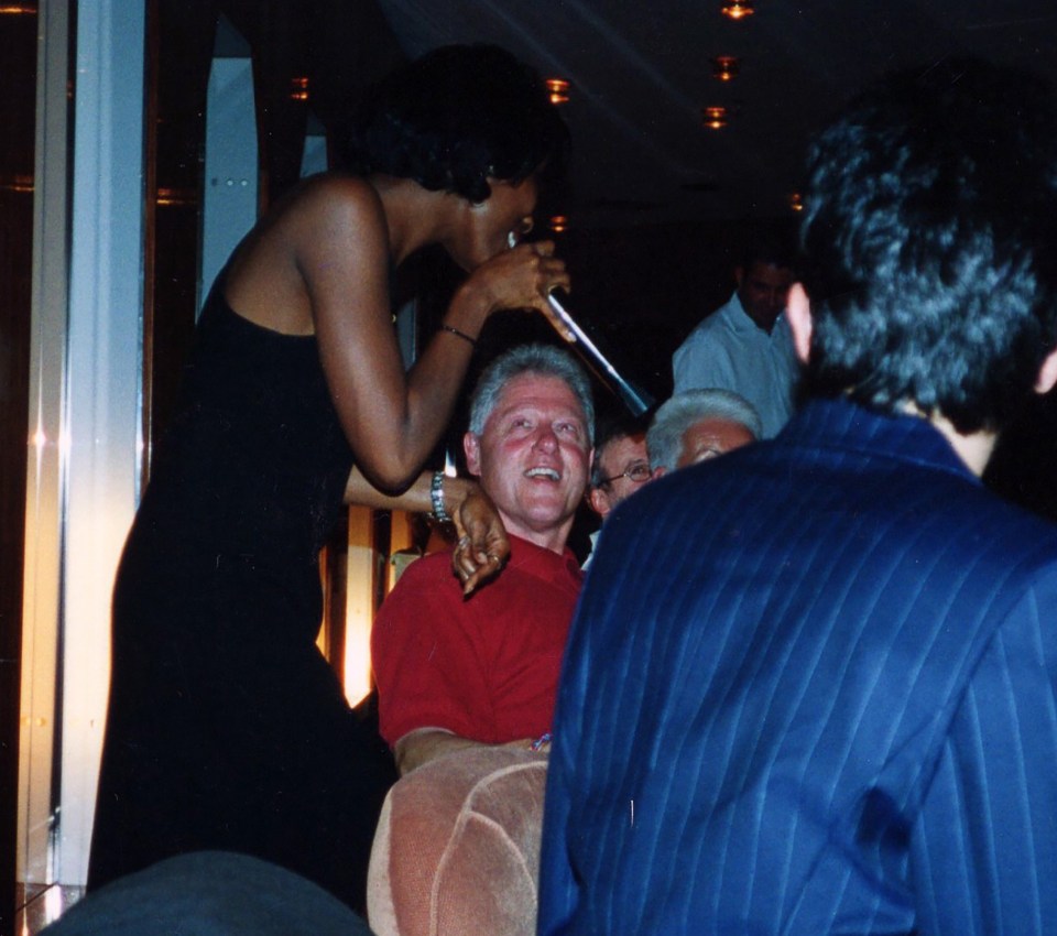 Bill Clinton is entertained by a singer on the trip to Africa