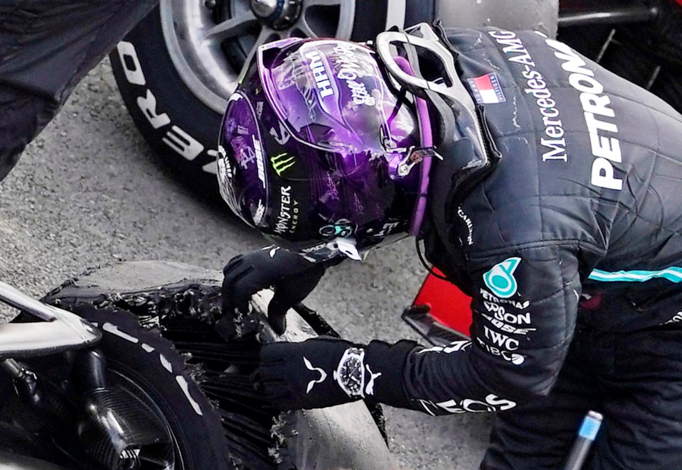 Lewis Hamilton peered inside his shredded tyre after the win