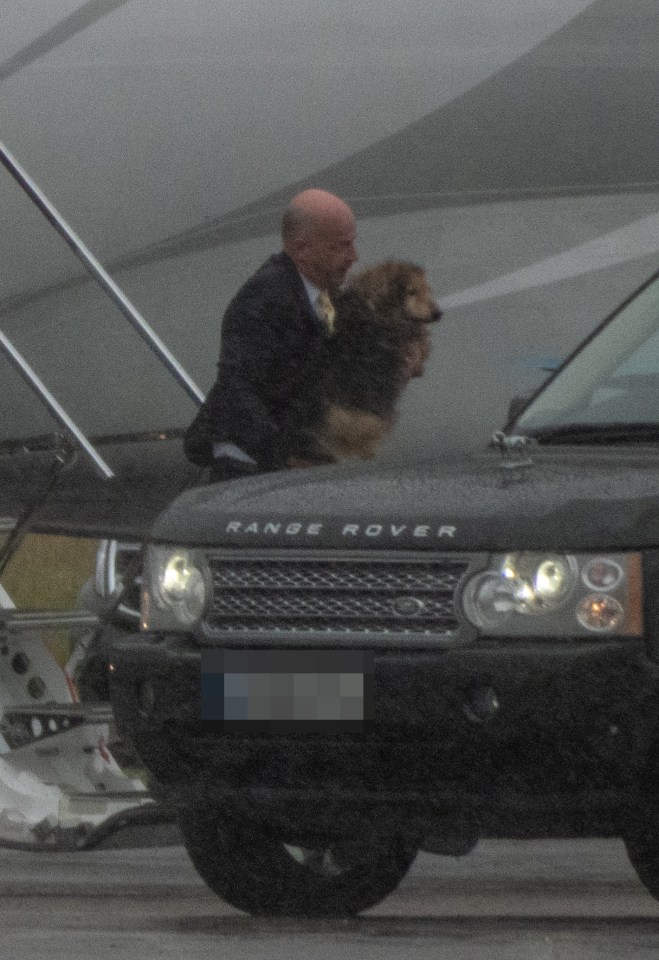 One of the Queen's beloved dogs is seen being carried off the plane