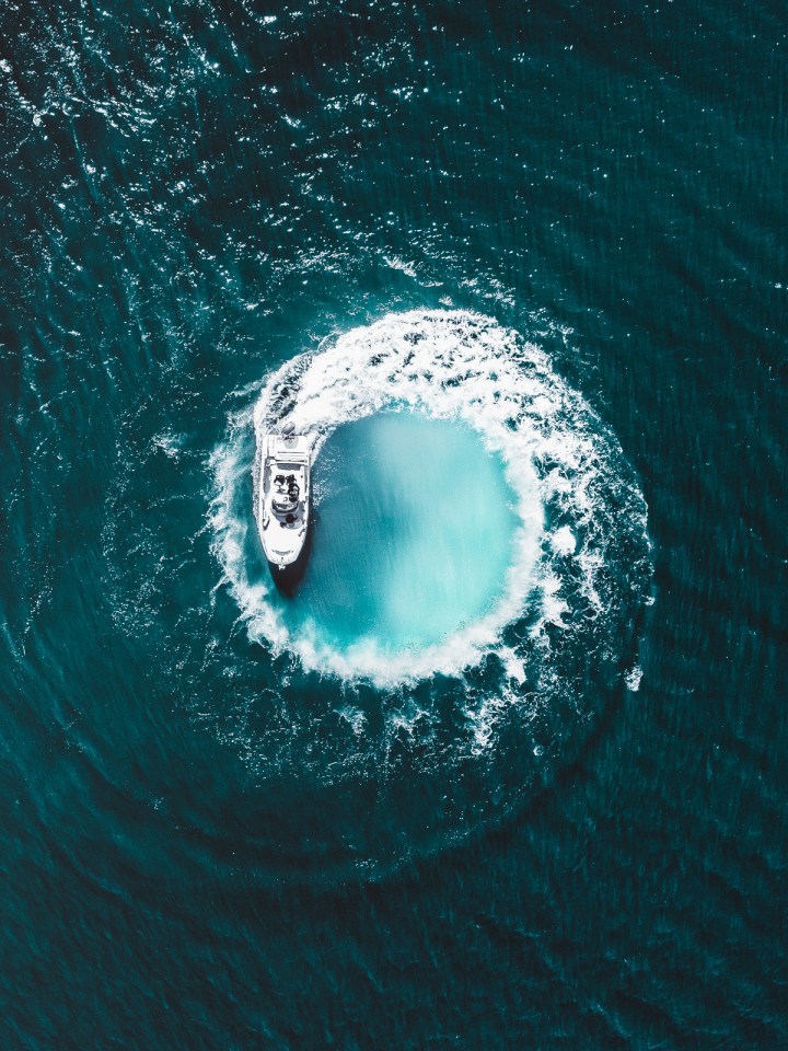 An aerial view of a boat circling in the sea