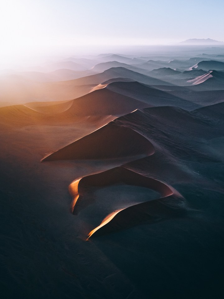 A morning helicopter soared above the mighty deserts of Namibia below a cloud inversion coming from the nearby coast of Swakopmund