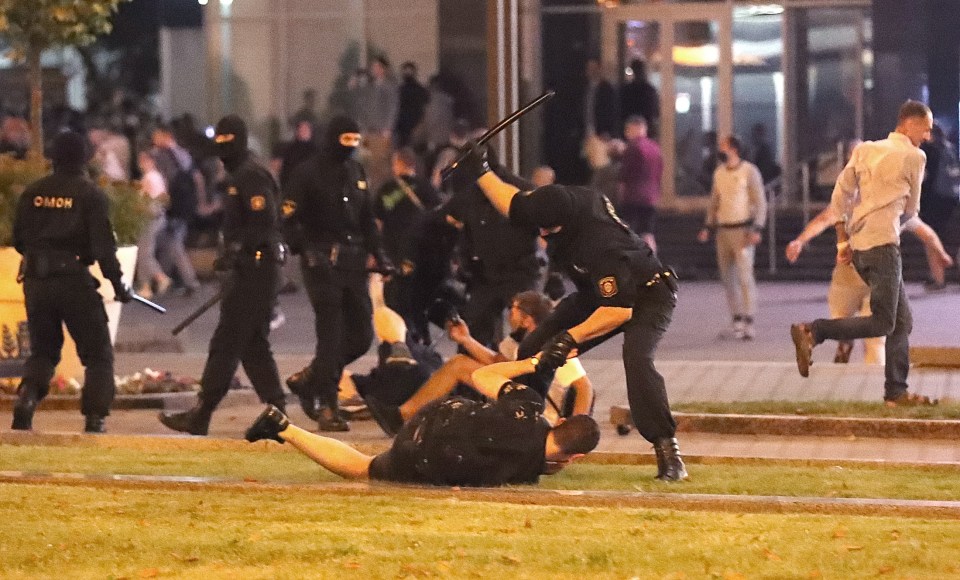 A cop batters protesters in the Belarusian capital yesterday