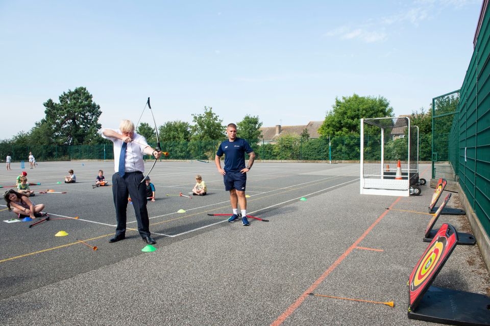 Mr Johnson using the bow during his visit to the Premier Education Summer Camp at Sacred Heart of Mary Girl's School, Upminster