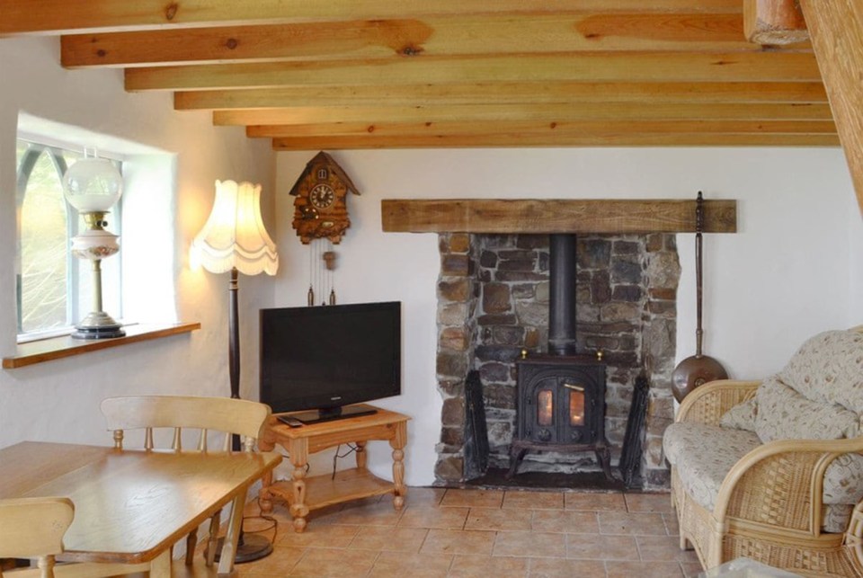 Inside is a log burner and grandfather clock, with wooden beamed ceilings