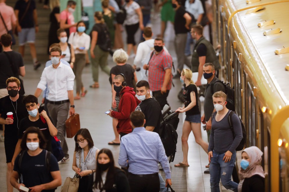 Commuters wearing face masks seen disembarking the train at Berlin's Alexanderplatz station