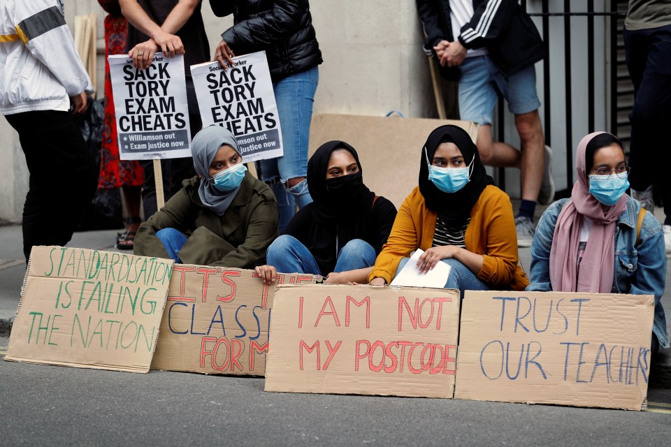 Furious A-level students hold placards as they protest outside the Department for Education today