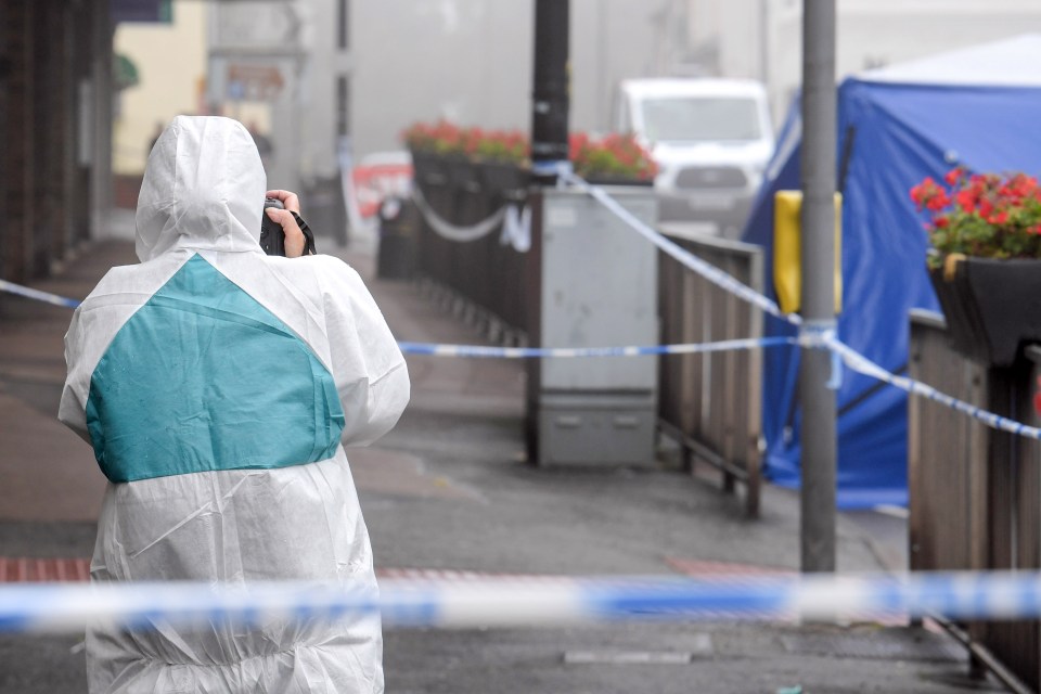 An officer takes photos of the crime scene where the man died