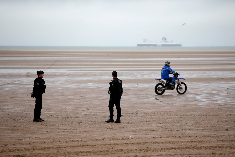 Police officers patrol the beach of Oye-Plage, northern France, near Calais after the tragedy