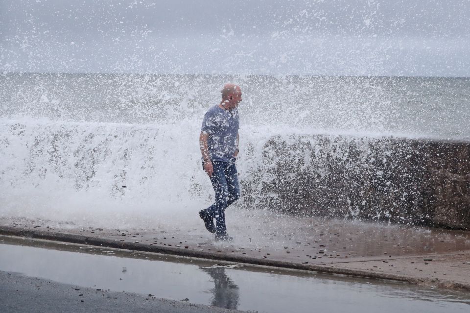 A man gets hit by a wave crashing on the Front Strand in Cork, Ireland