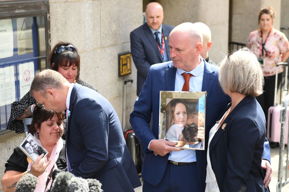 Families of the victims clutch photographs outside the Old Bailey today