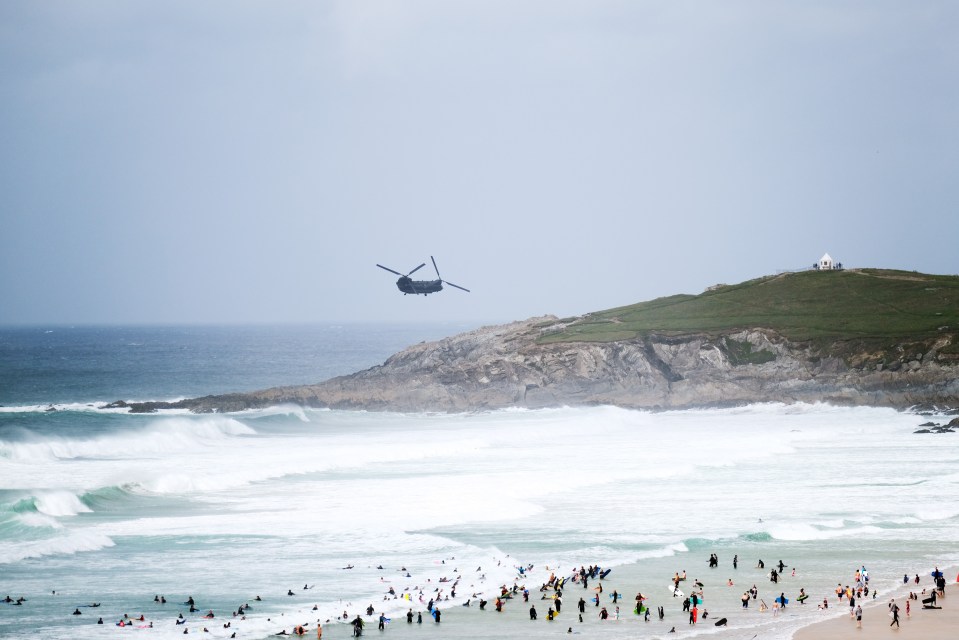 A helicopter flying over Fistral Beach as Storm Ellen rolls in