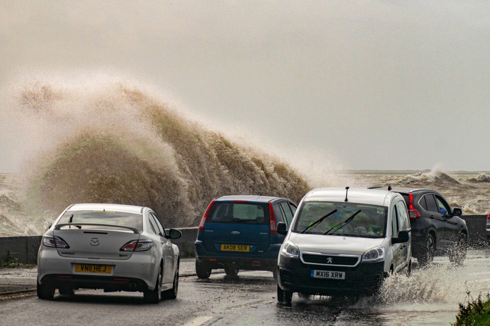 Large coastal waves crashing near a road in Cumbria