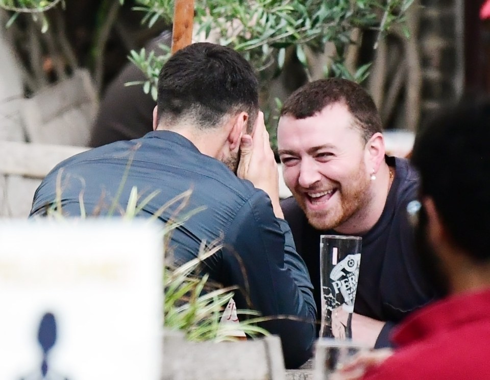 The singer was seen in hysterics as they chatted on a table outside