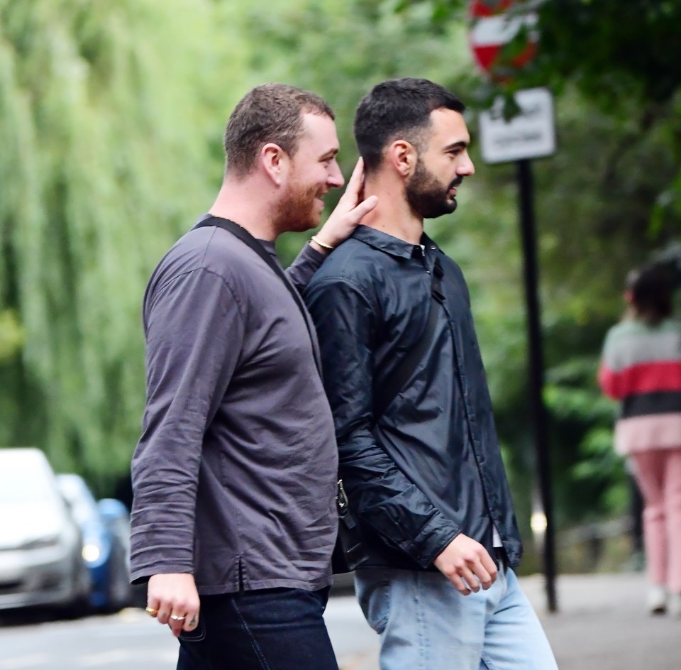 Sam rested a hand on the back of Francois' neck as they crossed the road