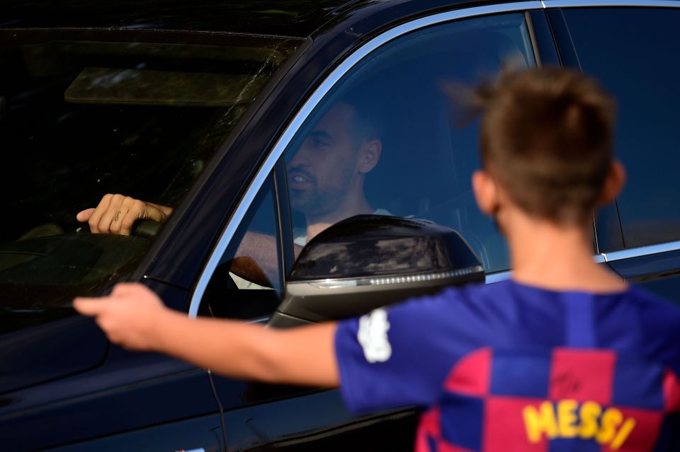 Sergio Busquets is greeted by a boy wearing a Barcelona kit