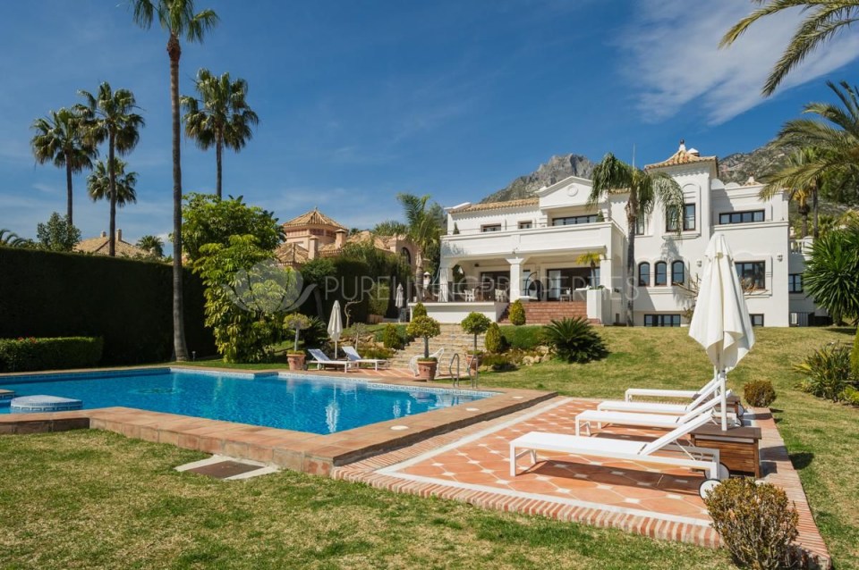 The swimming pool is decorated with deck chairs around it