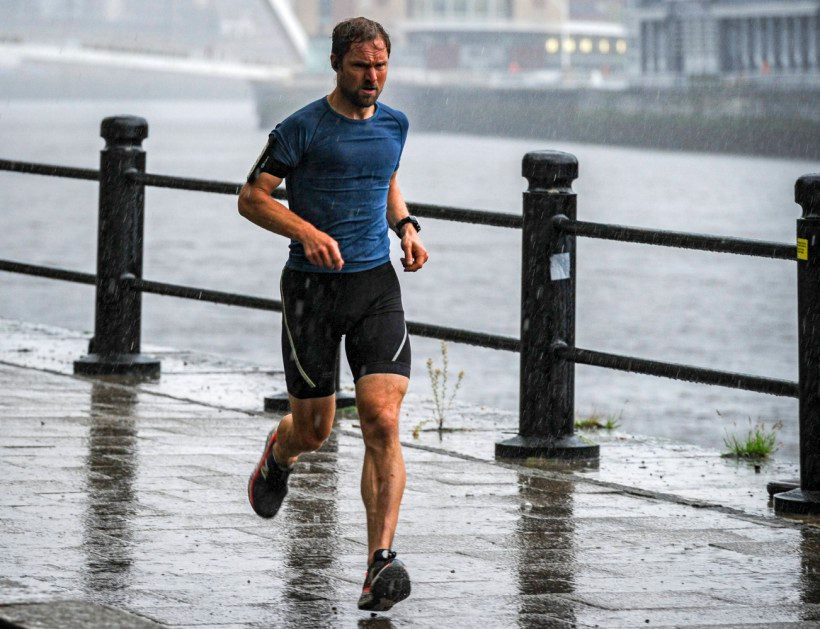 A jogger gets soaked while running along Newcastle Quayside on Friday