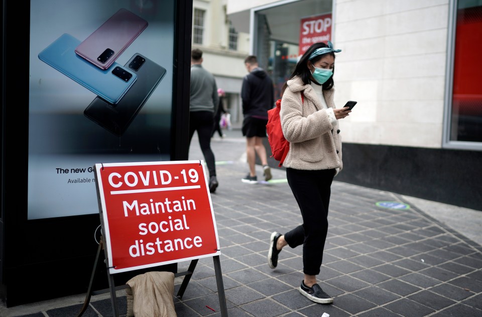 A woman wearing a mask walks through Liverpool