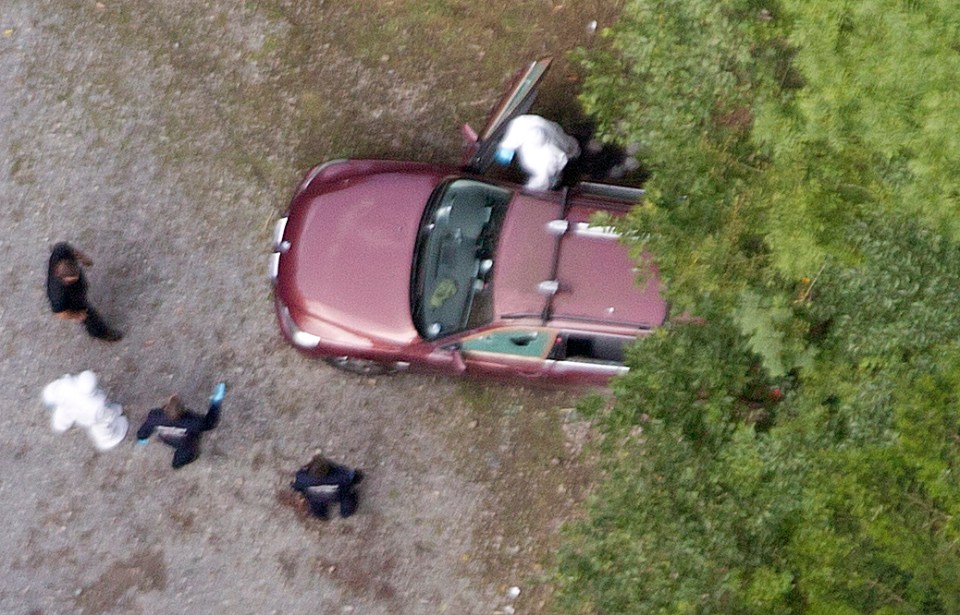 Police surround the scene where the British family and cyclist were shot dead