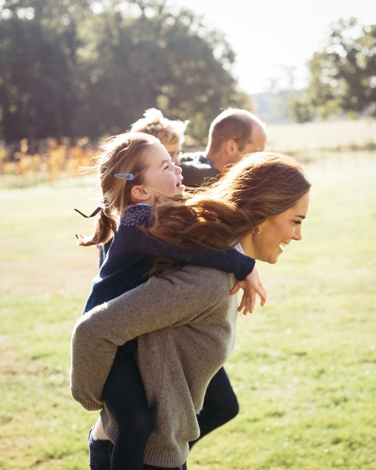 This beautiful shot of the Cambridges at Anmer Hall shows Kate giving Charlotte a piggyback