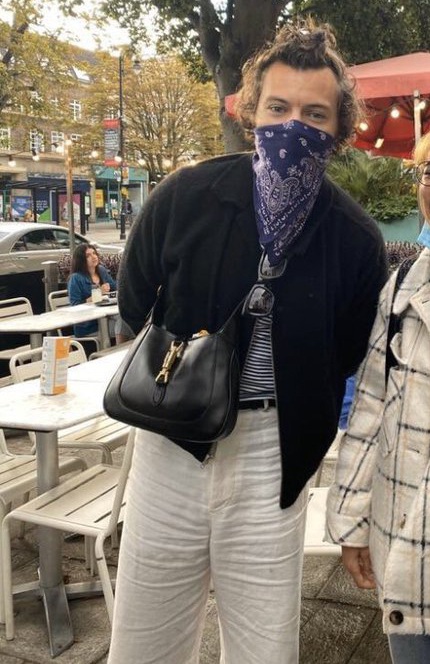 Harry Styles sported a bandana and handbag when he was snapped by a fan in London