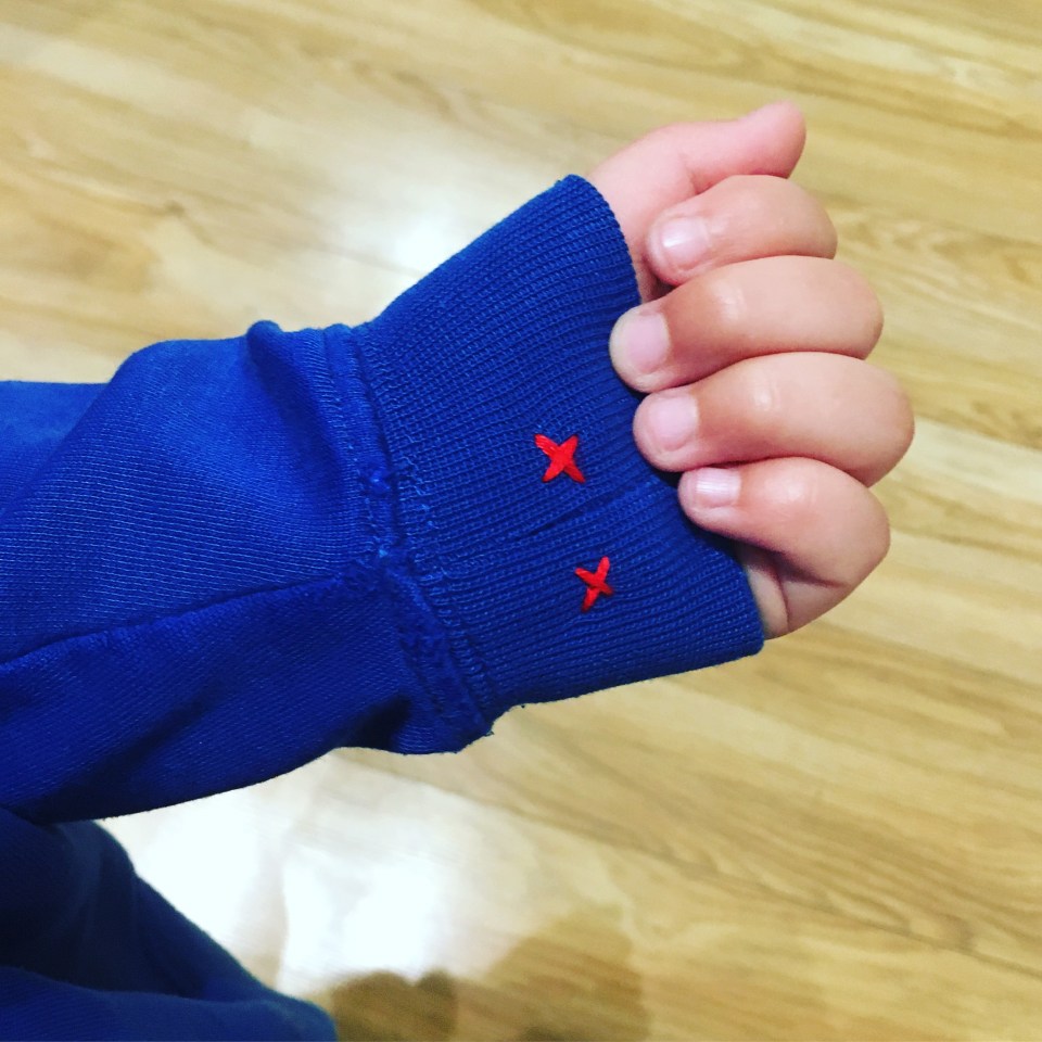 A mum has revealed how she sews two 'kisses' on her daughter's school jumper sleeve so she won't get upset going back to lessons