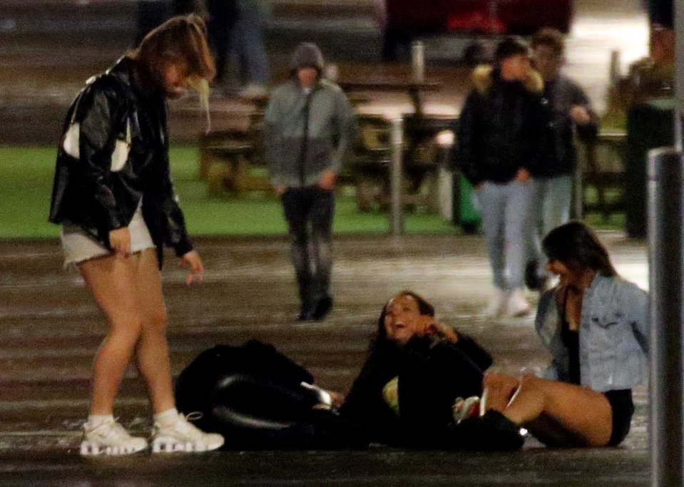 These girls were spotted laughing as they fell to the ground on their night out in the city centre 